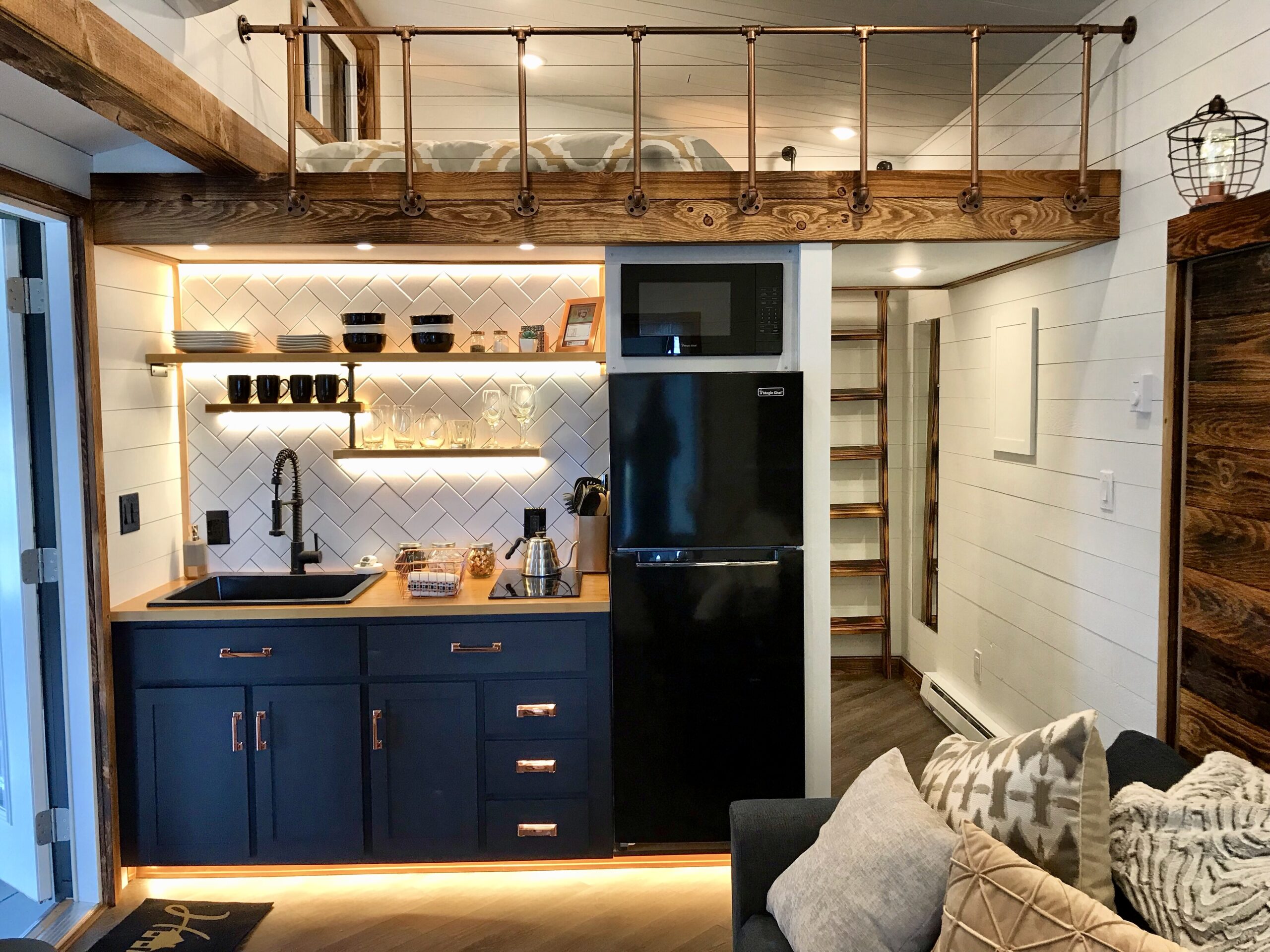 scaling hotel business - gorgeous interior, navy blue kitchen cabinets, tiny home, with bed loft above