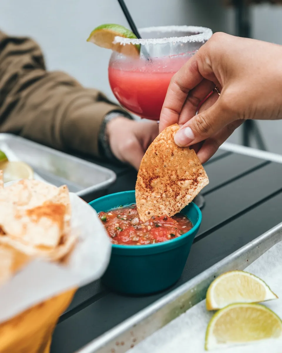 person double dipping nachos on sauce