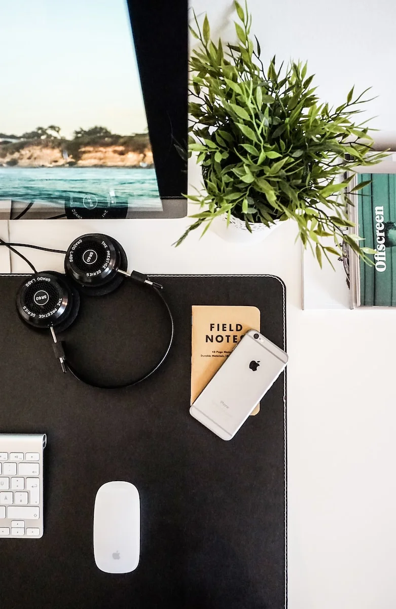 perfect outdoor workspace, black headphones beside space gray iPhone on brown table