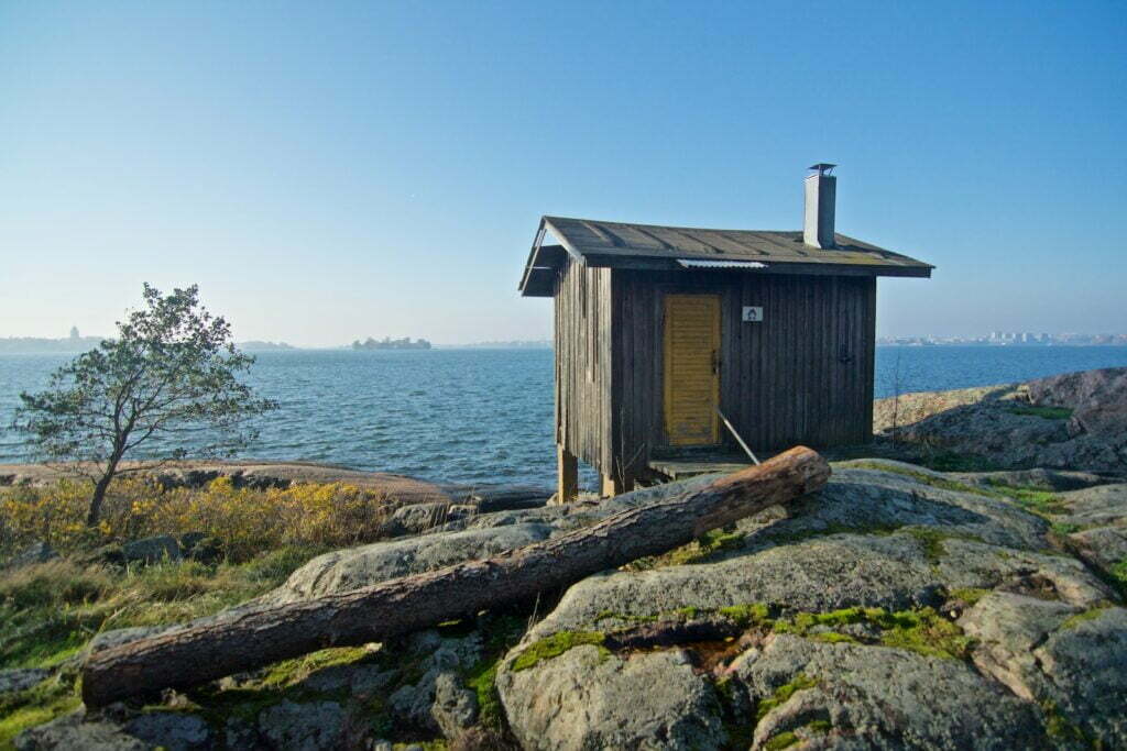 man cave shed, brown wooden shed near body of water under blue sky